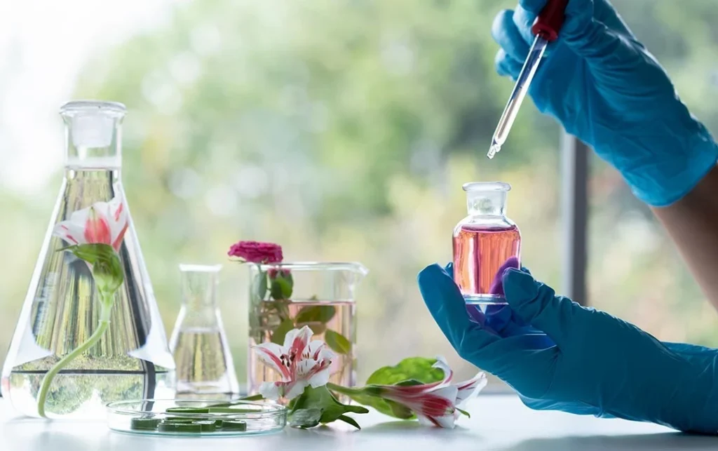 some perfumes botles and red flowers
